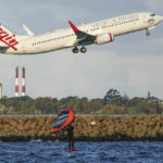 
              A man wing foils on Botany Bay as a passenger jet take off from Sydney Airport in Australia, Monday, Sept. 5, 2022. (AP Photo/Mark Baker)
            