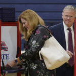 
              Republican gubernatorial candidate businessman Chris Doughty, right, and his wife Leslie, center, vote, Tuesday, Sept. 6, 2022, in Wrentham, Mass., in the state's primary election. Doughty, a political newcomer, is going up against Republican Geoff Diehl who has former President Donald Trump's endorsement. (AP Photo/Steven Senne)
            