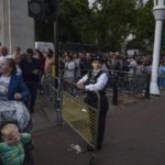 
              People wait in line to lay flowers for Queen Elizabeth II in front of Buckingham Palace, in London, Sept. 10, 2022. (AP Photo/Nariman El-Mofty)
            