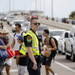 
              A Police Officer controls traffic as spectators walk on the Max Brewer Bridge after NASA scrubbed the launch attempt of the NASA Moon Rocket from Pad 39B at the Kennedy Space Center Titusville, Fla., Saturday, Sept. 3, 2022.(AP Photo/Terry Renna)
            