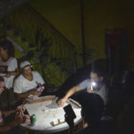 
              People play dominoes by flashlight during a blackout in Havana, Cuba, Wednesday, Sept. 28, 2022. Cuba remained in the dark early Wednesday after Hurricane Ian knocked out its power grid and devastated some of the country's most important tobacco farms when it hit the island's western tip as a major storm. (AP Photo/Ramon Espinosa)
            