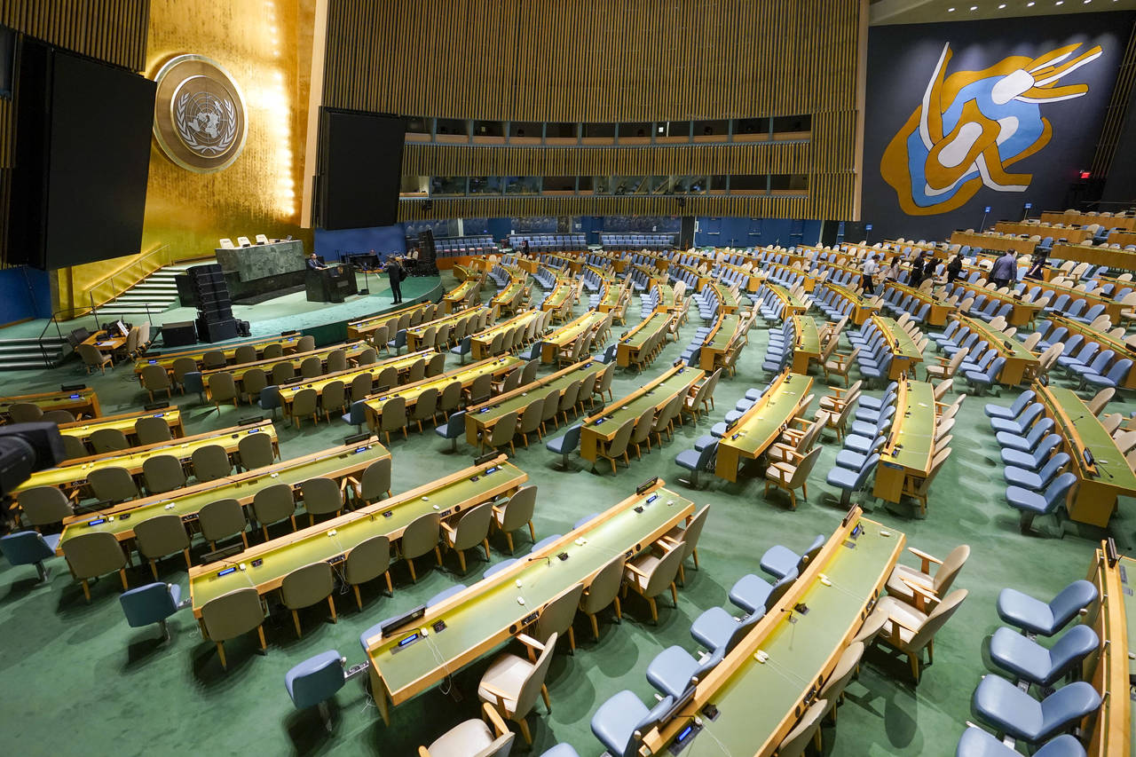 Visitors to the United Nations headquarters take photos at the General Assembly speaker's podium ah...