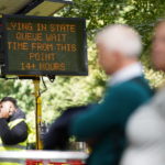 
              A sign in Southwark Park in London, informing members of the public that the queue to view Queen Elizabeth II lying in state ahead of her funeral on Monday is 14 hours plus, from that point, Friday Sept. 16, 2022. (James Manning/PA via AP)
            