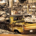 
              FILE - A scorched pickup truck sits in front of a Wakefield Avenue home destroyed by the Mill Fire on Saturday, Sept. 3, 2022, in Weed, Calif. A wood products company said Wednesday, Sept. 7, 2022 that it is investigating whether a fire that killed two people as it swept through a Northern California town was caused by the possible failure of a water-spraying machine used to cool ash at its veneer mill. (AP Photo/Noah Berger, File)
            