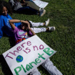 
              Giselle Barker, 14, top, and Azuri Brown, 15, listen to speakers for the Global Climate Strike protests in New York on Friday, Sept. 23, 2022. (AP Photo/Brittainy Newman)
            