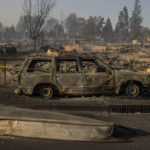 
              A boat is seen on a road in front of a burned vehicle in the Lincoln Heights neighborhood during the Mill Fire in Weed, Calif., Saturday, Sept. 3, 2022. (Stephen Lam/San Francisco Chronicle via AP)
            