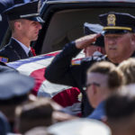 
              Officers salute the casket of Officer Seara Burton during  funeral services Monday, Sept. 26, 2022, inside Richmond High School in Richmond, Ind. Burton was shot and killed in the line of duty. (Mykal McEldowney/The Indianapolis Star via AP)
            
