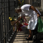 
              A woman places flower in front of the British embassy in Rome, Friday, Sept. 9, 2022. Queen Elizabeth II, Britain's longest-reigning monarch and a rock of stability across much of a turbulent century, died Thursday after 70 years on the throne. (AP Photo/Alessandra Tarantino)
            