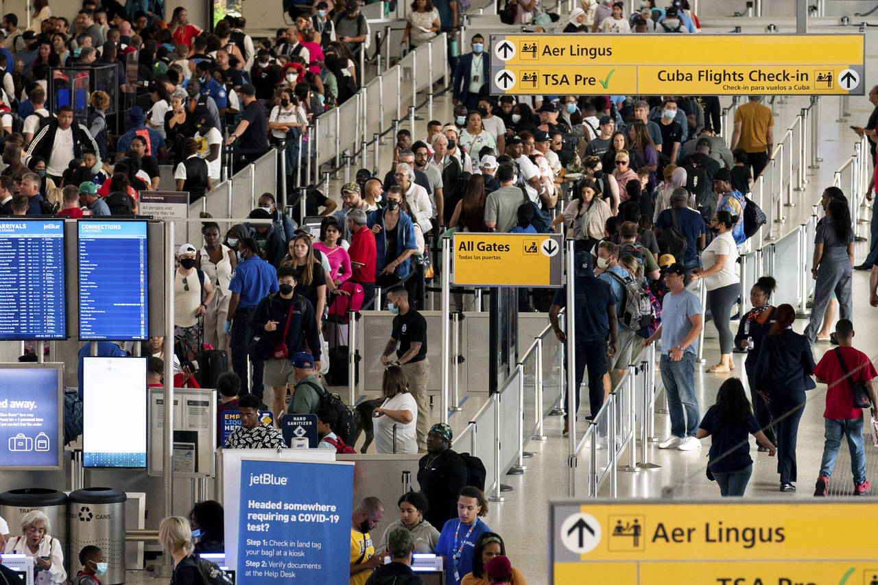 FILE - People wait in a TSA line at the John F. Kennedy International Airport in New York, Tuesday,...