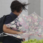 
              A person braves the strong wind caused by Typhoon Hinnamnor in Naha, Okinawa prefecture, Japan Sunday, Sept. 4, 2022. (Kyodo News via AP)
            