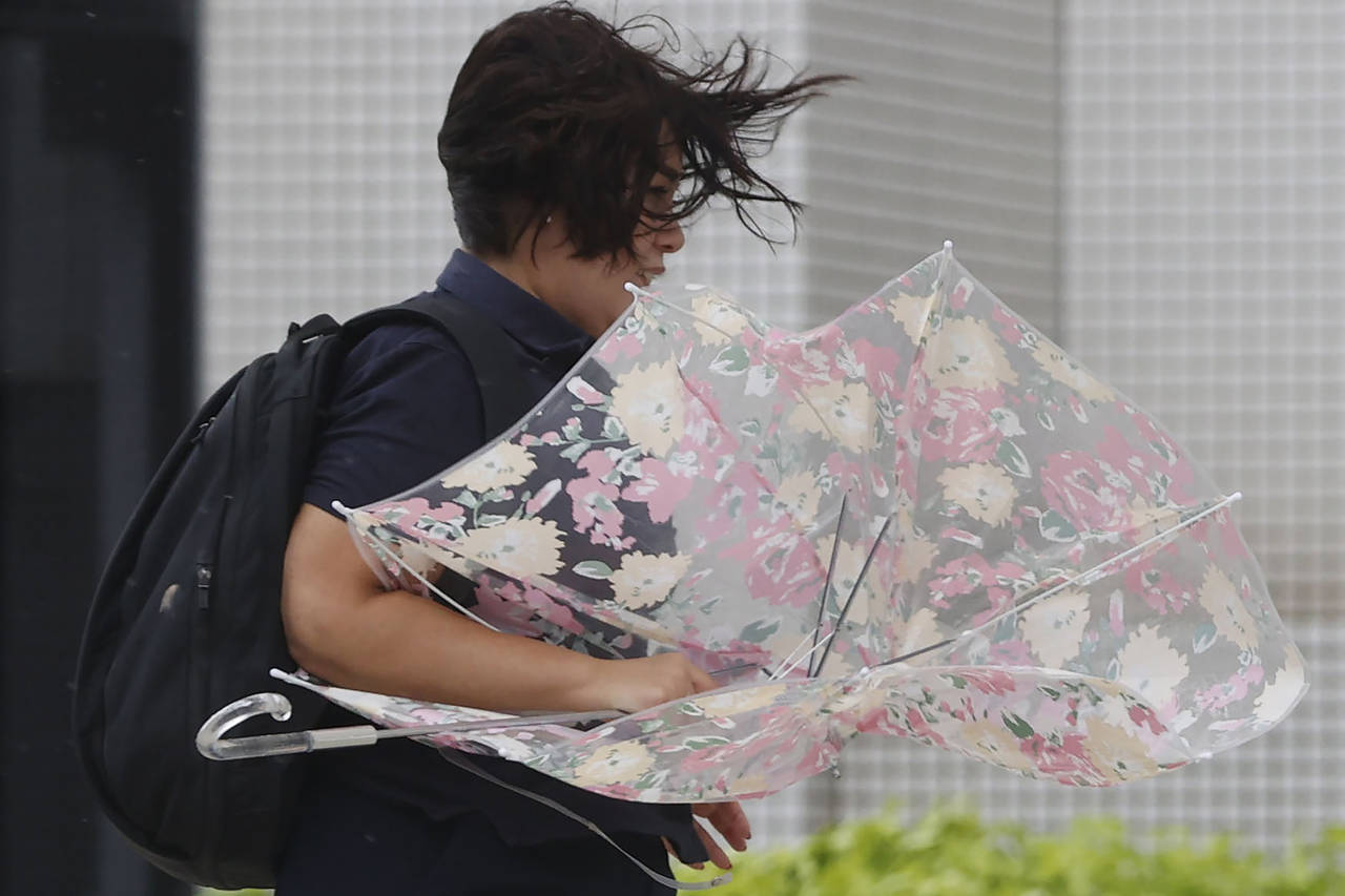 A person braves the strong wind caused by Typhoon Hinnamnor in Naha, Okinawa prefecture, Japan Sund...