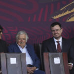 Uruguay's former President Jose Mujica, second from left, Bolivia's former President Evo Morales, left, and the brother and father of Julian Assange, John Shipton and Gabriel Shipton, attend Mexico's annual Independence Day military parade at the main square, the Zocalo, in Mexico City, Friday, Sept. 16, 2022. (AP Photo/Marco Ugarte)