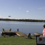 
              Alaska Republican U.S. House candidate Sarah Palin waves at a passing floatplane during a news conference at her lakeside home in Wasilla, Alaska, on Monday, Sept. 5, 2022, in which she called on fellow Republican Nick Begich to drop out of the race. Monday was the deadline for candidates to withdraw from the November general election. The race also includes Democrat Mary Peltola, who recently defeated Palin and Begich in a special election to serve the remainder of the late Rep. Don Young's term, which ends early next year. (AP Photo/Mark Thiessen)
            
