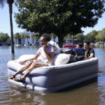 
              University of Central Florida students use an inflatable mattress as they evacuate an apartment complex near the campus that was totally flooded by rain from Hurricane Ian, Friday, Sept. 30, 2022, in Orlando, Fla. AP Photo/John Raoux)
            