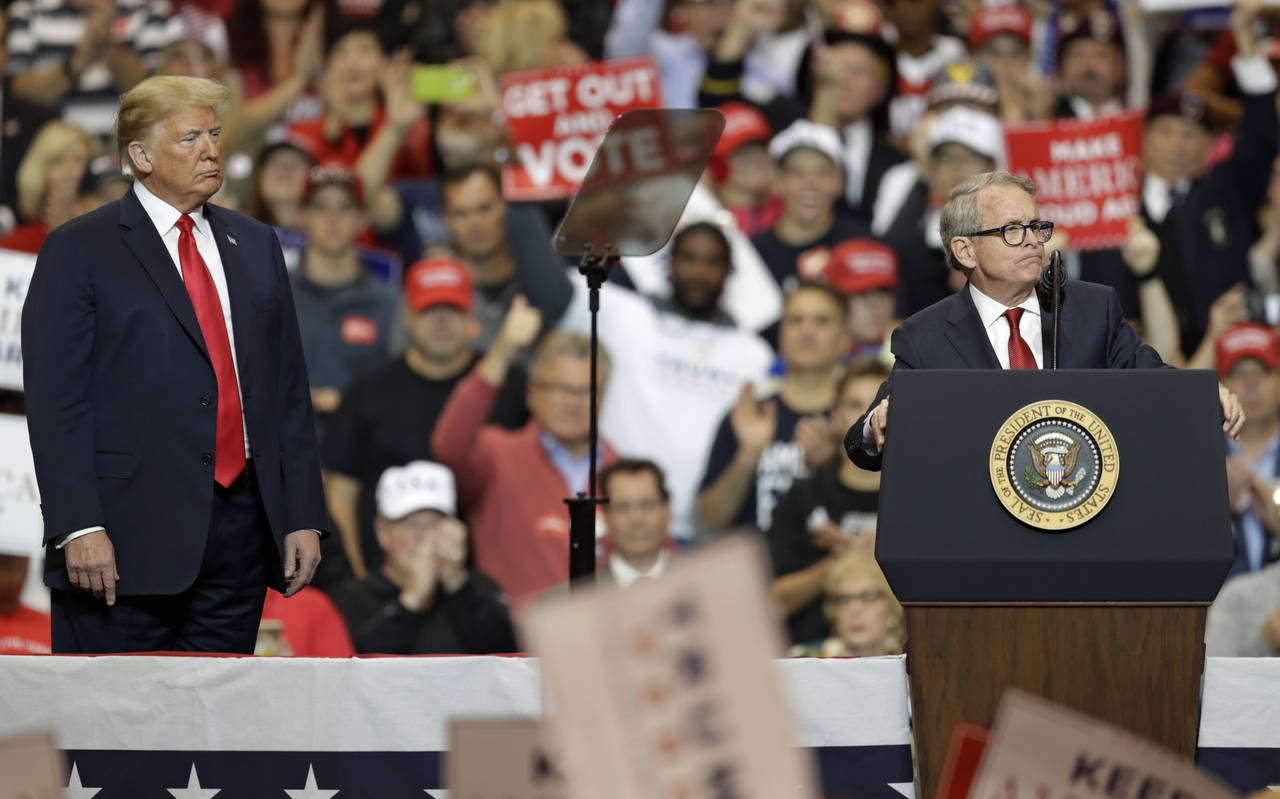 FILE - President Donald Trump listens as Ohio gubernatorial candidate Mike DeWine speaks at a campa...