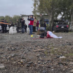 
              The dead body of a woman lies on the ground after a Russian rocket attack in Zaporizhzhia, Ukraine, Friday, Sept. 30, 2022. A Russian strike on the Ukrainian city of Zaporizhzhia killed at least 23 people and wounded dozens, an official said Friday, just hours before Moscow planned to annex more of Ukraine in an escalation of the seven-month war. (AP Photo/Viacheslav Tverdokhlib)
            