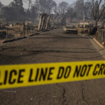 
              A police cordon is seen across a road in the Lincoln Heights neighborhood during the Mill Fire in Weed, Calif., Saturday, Sept. 3, 2022. (Stephen Lam/San Francisco Chronicle via AP)
            