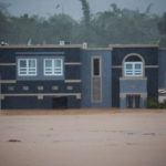 
              A home is submerged in floodwaters caused by Hurricane Fiona in Cayey, Puerto Rico, Sunday, Sept. 18, 2022.  According to authorities three people were inside the home and were reported to have been rescued.  (AP Photo/Stephanie Rojas)
            