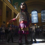 A large puppet named Little Amal walks around Grand Central Station in New York, Thursday, Sept. 15, 2022. New York City's latest celebrity visitor is stopping traffic even in this jaded, larger-than-life town. Little Amal, a 12-foot puppet of a 10-year-old Syrian refugee, is on a 17-day blitz through every corner of the Big Apple as part of a theater project hoping to raise awareness about immigration. (AP Photo/Seth Wenig)