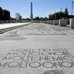 
              FILE - A Fascist motto reading in Italian "Many enemies, much honor", decorates the mosaic pavement on the avenue from the Olympic stadium to a fascist-era obelisk, in Rome's Foro Italico sporting ground, Thursday, May, 16, 2019. The Brothers of Italy party has won the most votes in Italy’s national election. The party has its roots in the post-World War II neo-fascist Italian Social Movement. Giorgia Meloni has taken Brothers of Italy from a fringe far-right group to Italy’s biggest party.  (AP Photo/Gregorio Borgia, File)
            