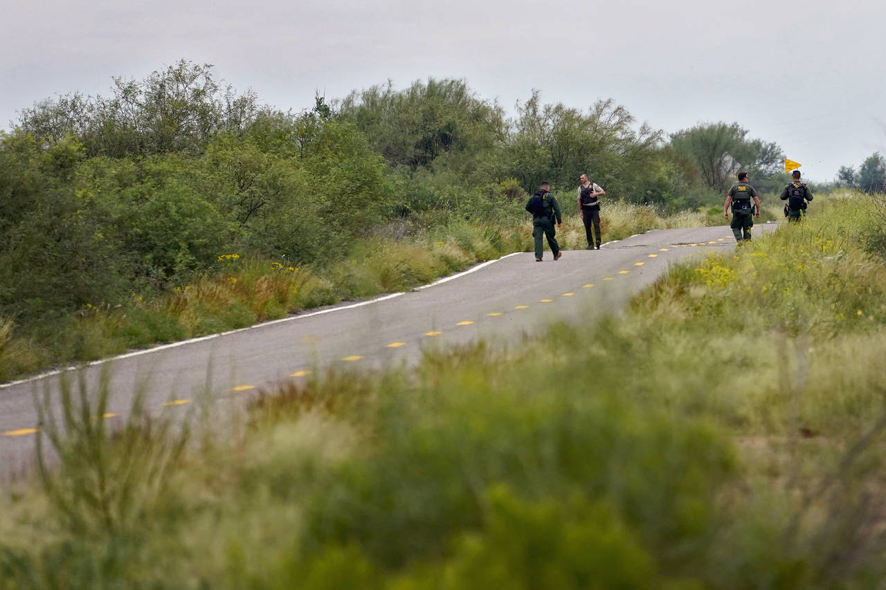 U.S. Border Patrol agents and an Arizona Fish and Game Officer search for a group of migrants evadi...