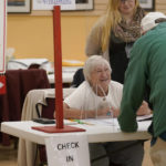 
              An election worker, center, assists a voter, right, in the Massachusetts primary election at a polling place, Tuesday, Sept. 6, 2022, in Attleboro, Mass. (AP Photo/Steven Senne)
            