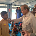 
              In this handout photo released by Press Information Department, Prime Minister Shahbaz Sharif, second right, talks a student at a makeshift school inside a tent in the flood-hit area of Suhbatpur in Baluchistan, Pakistan. Sharif on Wednesday promised the country's millions of homeless people that the government will ensure they are paid to rebuild their homes and return to their lives after the country's worst-ever floods. (Press Information Department via AP)
            