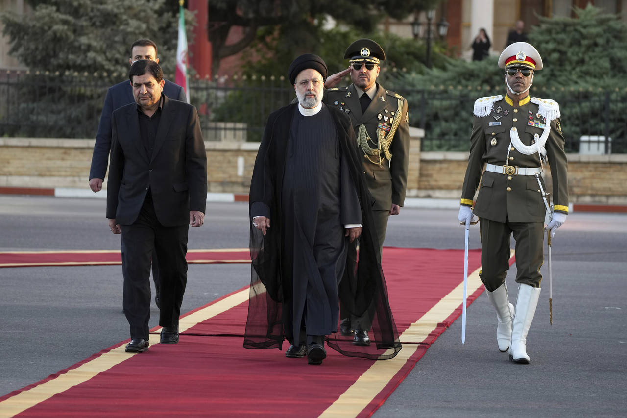 Iranian President Ebrahim Raisi, center, reviews an honor guard during his official departure cerem...