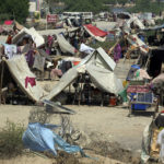 
              Victims of the unprecedented flooding from monsoon rains take refuge in Jaffarabad, a district of Pakistan's southwestern Baluchistan province, Monday, Sept. 5, 2022. The U.N. refugee agency rushed in more desperately needed aid Monday to flood-stricken Pakistan as the nation's prime minister traveled to the south where rising waters of Lake Manchar pose a new threat. (AP Photo/Fareed Khan)
            