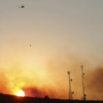 
              A helicopter carries water on a longline to a wildfire near Salem, Ore., at sunset Friday, Sept. 9, 2022. Climate change is bringing drier conditions to the Pacific Northwest and that requires strategies that have been common in fire-prone California for the past decade or more, said Erica Fleishman, director of the Oregon Climate Change Research Institute at Oregon State University. (AP Photo/Andrew Selsky)
            