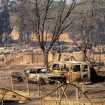 
              Vehicles and and homes destroyed by the Mill Fire line a neighborhood in Weed, Calif., on Saturday, Sept. 3, 2022. (AP Photo/Noah Berger)
            