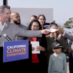 
              Gov. Gavin Newsom, left, hands the climate change bill to the author, Assemblyman Robert Rivas, D-Hollister, right, during a signing ceremony at Mare Island, in Vallejo, Calif., Friday, Sept. 16, 2022. Riva's bill was among the package of legislation that Newsom signed that accelerates the climate goals of the nation's most populous state.(AP Photo/Rich Pedroncelli)
            