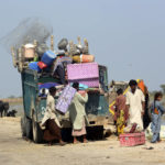 
              A family carry belongings from their flooded home after heavy rain in Qambar Shahdadkot district of Sindh Province, of Pakistan, Friday, Sep. 2, 2022. Planes carrying fresh supplies are surging across a humanitarian air bridge to flood-ravaged Pakistan as the death toll surged past 1,200, officials said Friday, with families and children at special risk of disease and homelessness. (AP Photo/Fareed Khan)
            