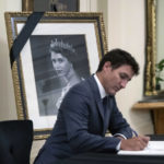 
              Prime Minister Justin Trudeau signs a book of condolences for Queen Elizabeth II, at Rideau Hall in Ottawa, Ontario on Friday, Sept. 9, 2022. (Justin Tang/The Canadian Press via AP)
            