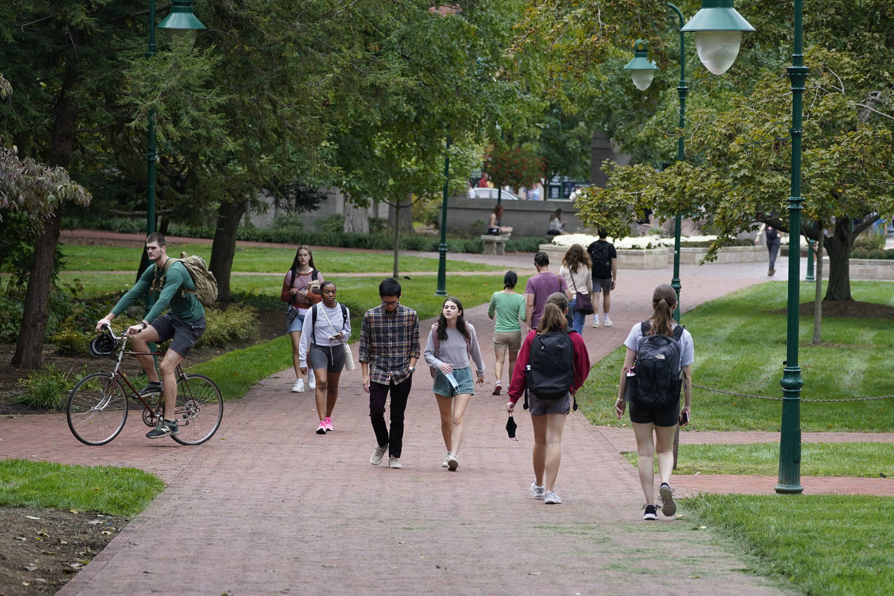 FILE - Students walk to and from classes on the Indiana University campus, Thursday, Oct. 14, 2021,...
