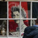 
              A man looks at a portrait of Queen Elizabeth II in a shop window near Windsor Castle in Windsor, England, Friday, Sept. 9, 2022. Queen Elizabeth II, Britain's longest-reigning monarch and a rock of stability across much of a turbulent century, died Thursday after 70 years on the throne. She was 96. (AP Photo/Frank Augstein)
            