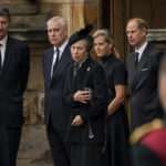 
              From left, Vice Admiral Timothy Laurence, Prince Andrew, Princess Anne, Sophie the Countess of Wessex and Prince Edward watch as the coffin of Queen Elizabeth II, draped with the Royal Standard of Scotland, completes its journey from Balmoral to the Palace of Holyroodhouse, where it will lie in rest for a day,  in Edinburgh, Sunday, Sept. 11, 2022. Queen Elizabeth II, Britain's longest-reigning monarch and a rock of stability across much of a turbulent century, died Thursday Sept. 8, 2022, after 70 years on the throne. She was 96.  (Aaron Chown/Pool Photo via AP)
            