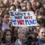 
              A sign reading "I want a hot date, not a hot planet" is held up in the crowd during a demonstration by climate activists in Berlin, Friday, Sept. 23, 2022. Youth activists staged a coordinated “global climate strike” on Friday to highlight their fears about the effects of global warming and demand more aid for poor countries hit by wild weather. (Monika Skolimowska/dpa via AP)
            