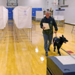
              New Hampshire Republican U.S. Senate candidate Don Bolduc carries his ballot before casting his vote, with his dog "Victor", while voting, Tuesday, Sept. 13, 2022, in Stratham, N.H. (AP Photo/Charles Krupa)
            