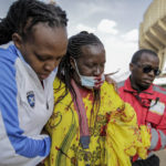 
              Medics treat an injured woman who was beaten by police after people broke through barriers causing a stampede when they tried to force their way into Kasarani stadium where the inauguration of Kenya's new president William Ruto is due to take place later today, in Nairobi, Kenya Tuesday, Sept. 13, 2022. (AP Photo/Brian Inganga)
            