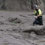 
              A worker with the Yucaipa Valley Water District threads through knee-deep mud while repairing a reservoir used as a drinking source in the aftermath of a mudslide, Tuesday, Sept. 13, 2022, in Oak Glen, Calif. (AP Photo/Marcio Jose Sanchez)
            