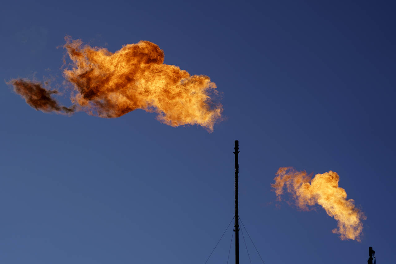 FILE - Flares burn off methane and other hydrocarbons at an oil and gas facility in Lenorah, Texas,...