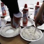 
              FILE - Students prepare whipped cream pies before a celebration of pi at the Hamtramck Academy Tuesday, March 14, 2017, in Hamtramck, Mich. On Friday, Sept. 2, 2022, The Associated Press reported on stories circulating online incorrectly claiming a New York law that aims to crack down on nitrous oxide abuse makes it illegal for anyone under age 21 to purchase a can of whipped cream. (AP Photo/Carlos Osorio, File)
            