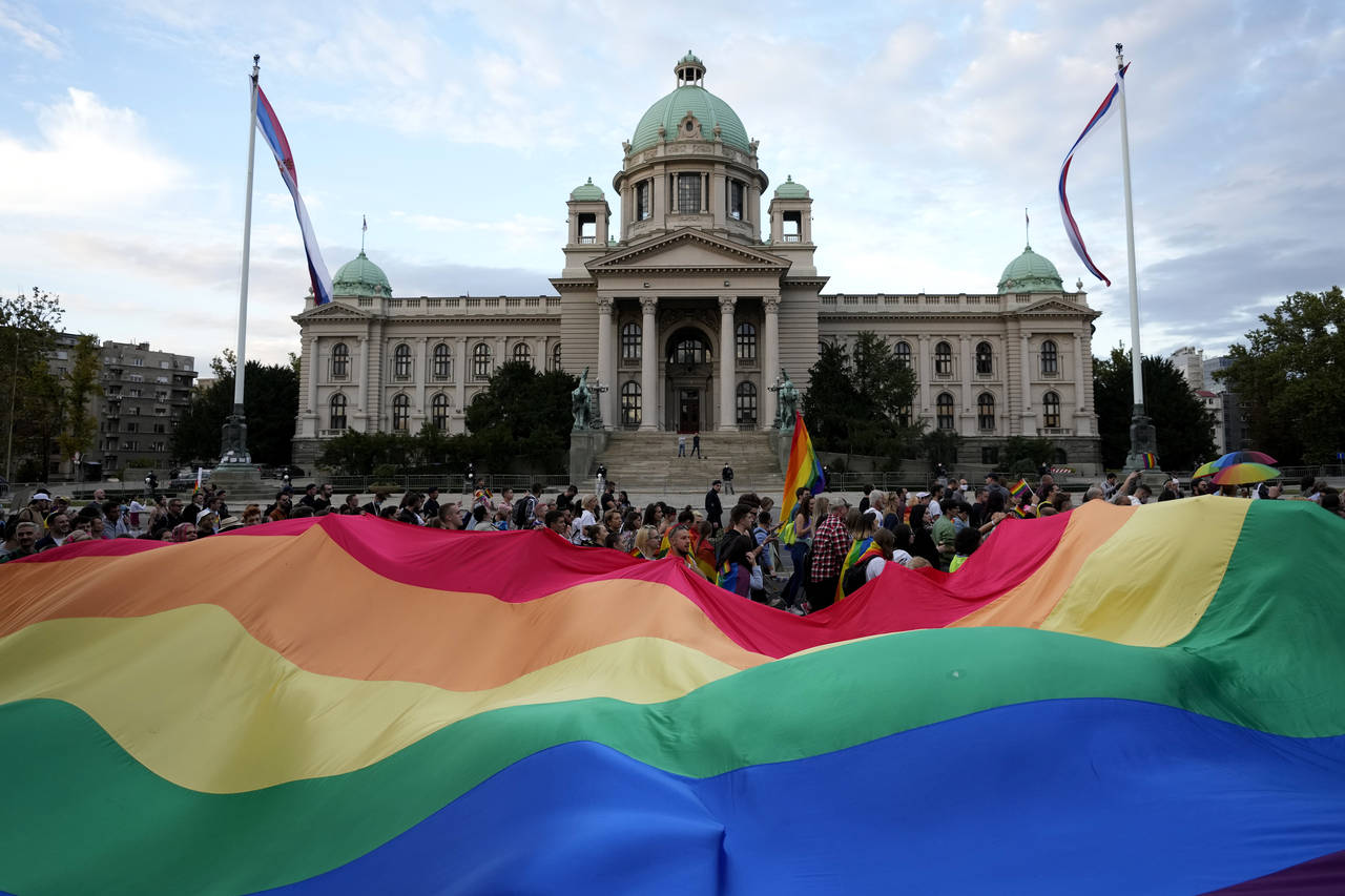 FILE - Participants carry large rainbow flag in front of the parliament building as they take part ...