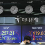 
              A currency trader watches computer monitors near the screens showing the Korea Composite Stock Price Index (KOSPI), left, and the foreign exchange rate between U.S. dollar and South Korean won at a foreign exchange dealing room in Seoul, South Korea, Monday, Sept. 26, 2022. Asian shares were mostly lower Monday, reflecting pessimism over weakness on Wall Street as the squeeze by central banks around the world to curb inflation weighs on investor sentiments. (AP Photo/Lee Jin-man)
            
