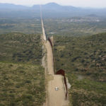 
              The wall along the border between the United States and Mexico, at right, abruptly ends as it cuts through the base of the Baboquivari Mountains, Thursday, Sept. 8, 2022, near Sasabe, Ariz. The desert region located in the Tucson sector just north of Mexico is one of the deadliest stretches along the international border with rugged desert mountains, uneven topography, washes and triple-digit temperatures in the summer months. This border section consists of wall, bollards or no barrier at all and has become a corridor of choice for migrants who don't turn themselves in right after crossing or apply for protection legally. (AP Photo/Giovanna Dell'Orto)
            