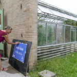 
              Poll supervisor Debbie Schimberg puts out a sign marking the entrance for voters for the state's primary election at the Roger Williams Park Botanical Center in Providence, R.I., Tuesday, Sept. 13, 2022. (AP Photo/David Goldman)
            