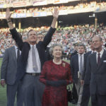 
              FILE - President George H. W. Bush escorts Queen Elizabeth II and Prince Philip on the field at Memorial Stadium on May 15, 1991, in Baltimore, before the Orioles played the Oakland A's. The Queen watched her first baseball game. Queen Elizabeth II, Britain's longest-reigning monarch and a rock of stability across much of a turbulent century, died Thursday, Sept. 8, 2022, after 70 years on the throne. She was 96. (AP Photo/Greg Gibson, File)
            