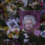 
              A painting of the Queen Elizabeth II is seen next to flowers at Green Park, near Buckingham Palace, in London, Sunday, Sept. 18, 2022. The Queen will lie in state in Westminster Hall for four full days before her funeral on Monday Sept. 19. (AP Photo/Felipe Dana)
            