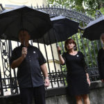 
              FILE - Members of Hungary's Teachers' Union (PSZ) stand during a protest, at a school year opening event, with black umbrellas over their heads to signify the problems of education, in Budapest, Hungary, Thursday, Sept. 1, 2022. Public schools in Poland and Hungary are facing a shortage of teachers at a time when both countries are taking in many Ukrainian refugee children. For years, teachers have been fleeing public schools over grievances regarding low wages and a sense of not being valued by their governments. (AP Photo/Anna Szilagyi, File)
            